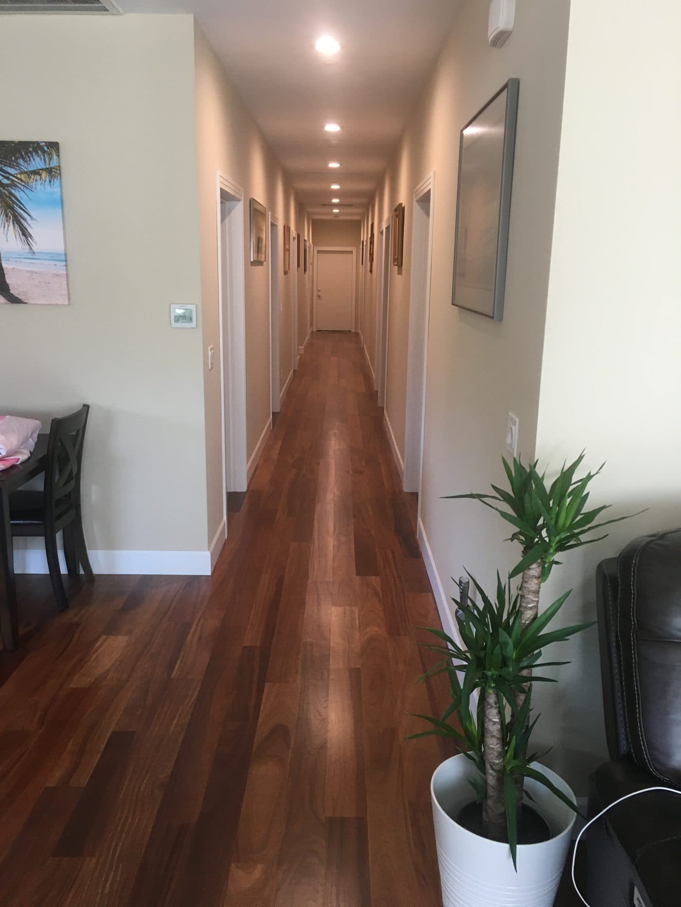 Warm hardwood hallway leading to the guest rooms