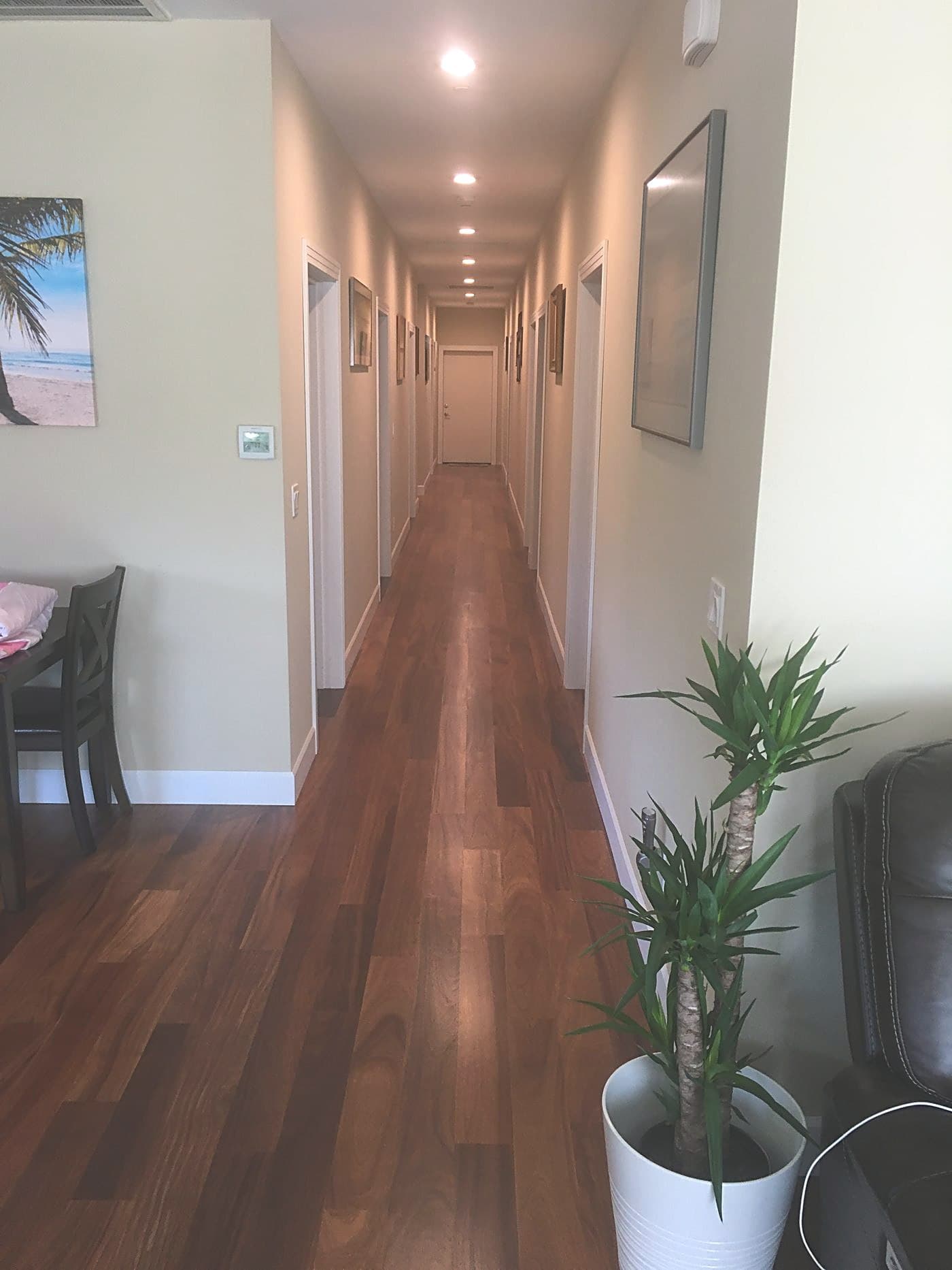 Warm hardwood hallway leading to the guest rooms
